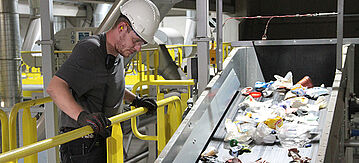 Ein Mann an einer Kunststoffrecyclingmaschine
