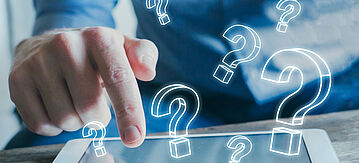 Mann tippt mit seinem Finger auf das Display eines Tablets