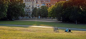 Zwei Personen sitzen in einem leeren Park in Berlin-Kreuzberg